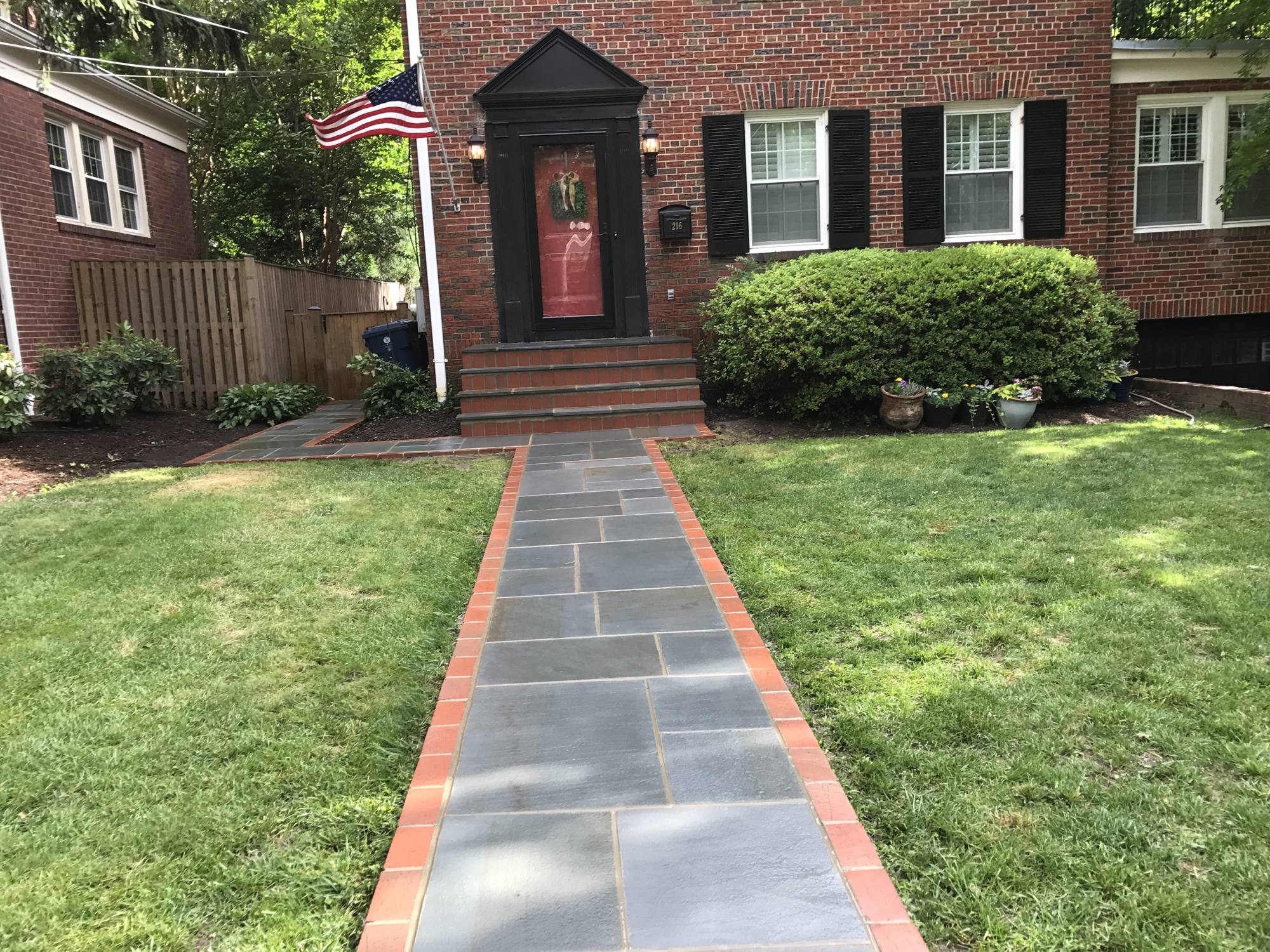 Bluestone front walkway with brick border at a brick colonial in Northern Virginia