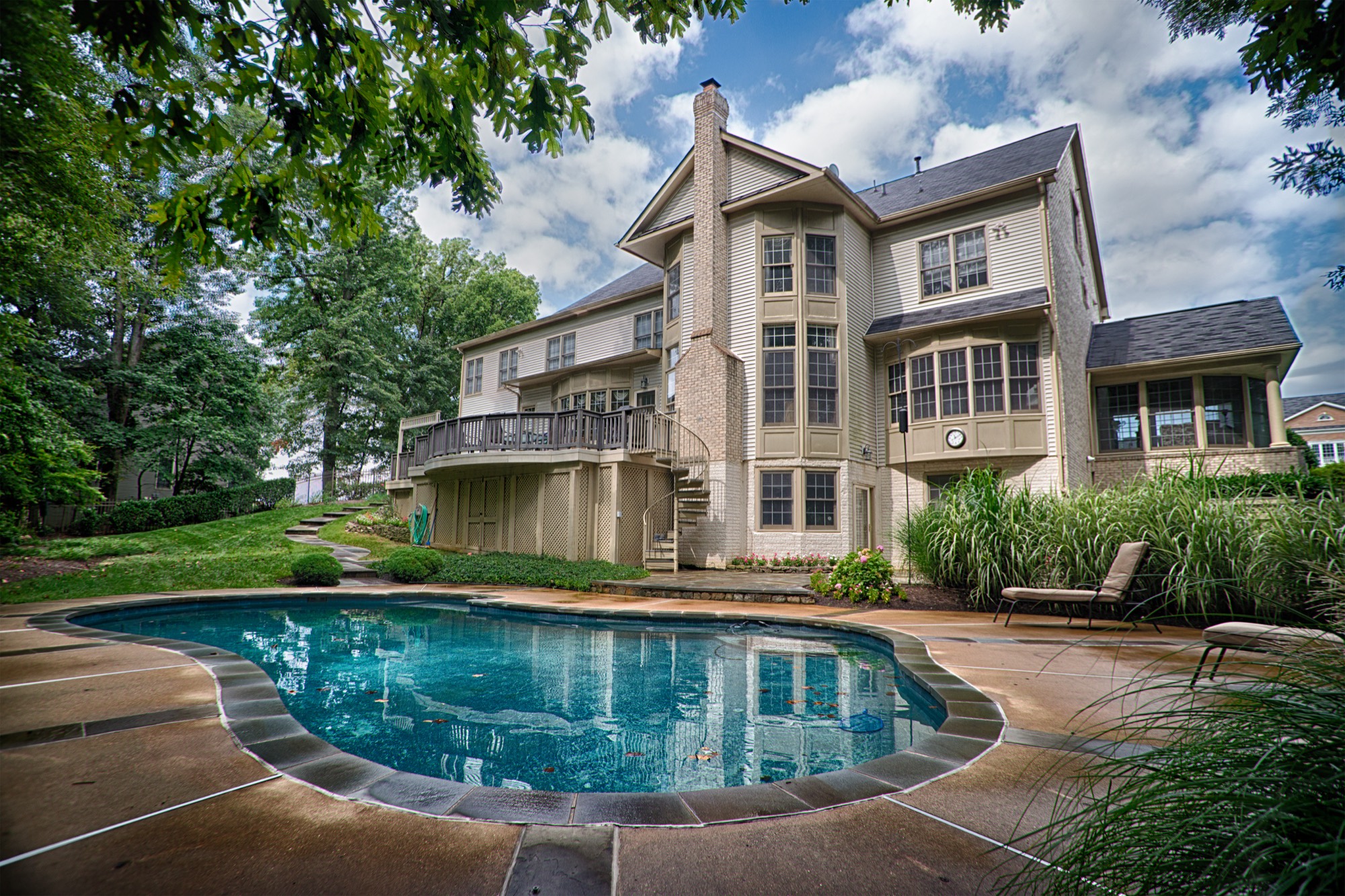 Backyard pool with natural stone pool deck and patio in Northern Virginia