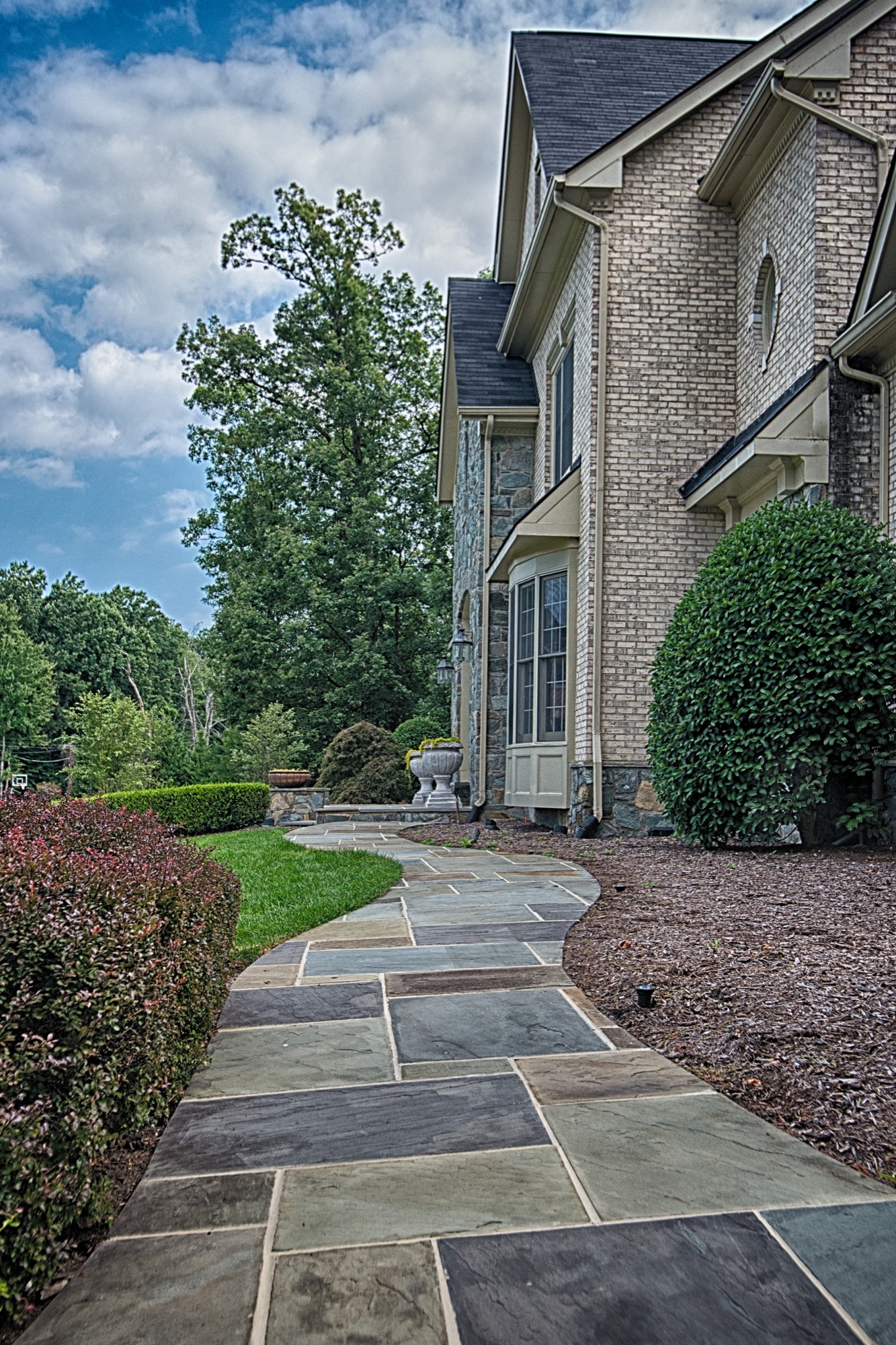 Flagstone walkway alongside a brick and stone home in Northern Virginia