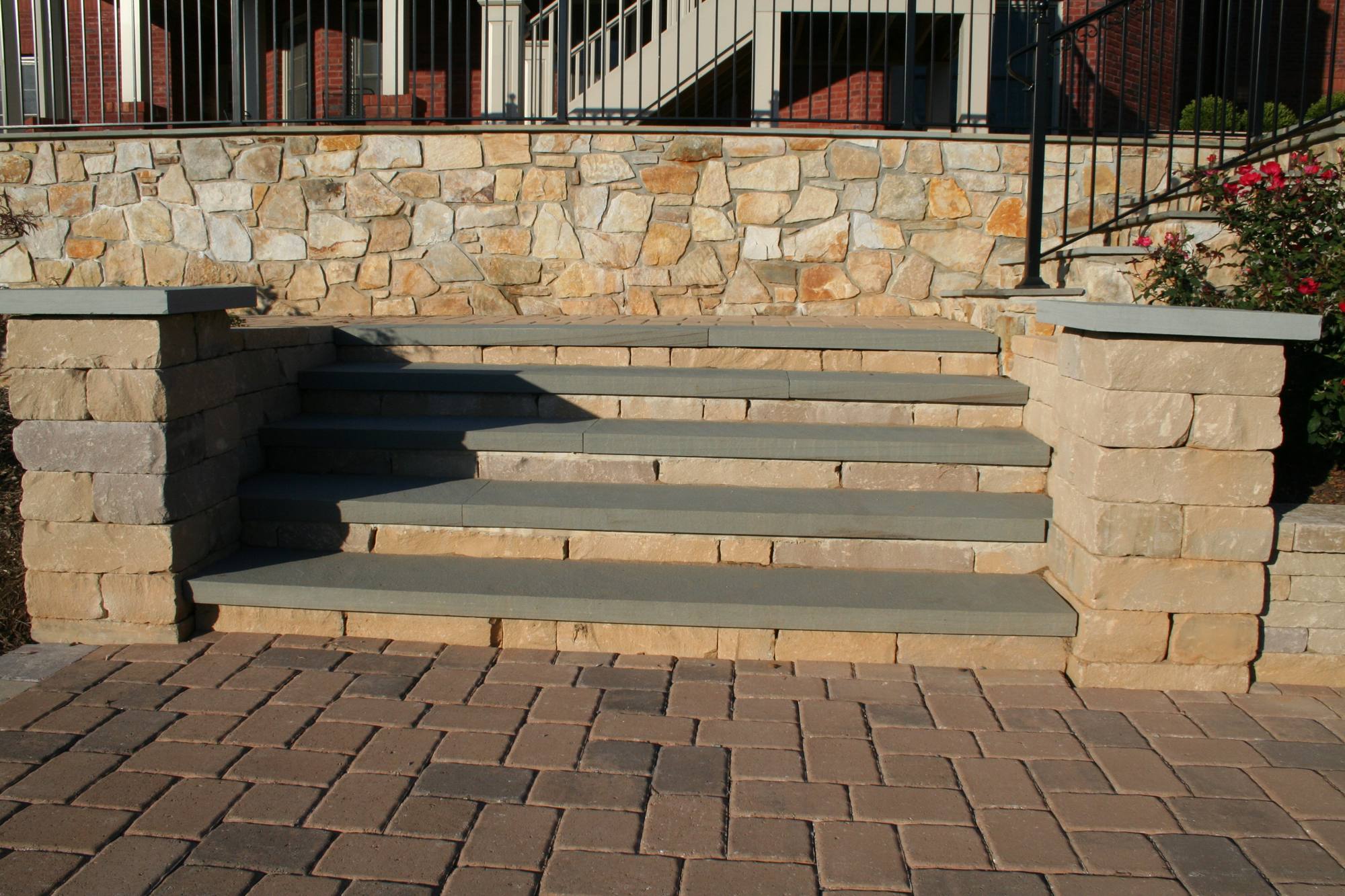 Stone steps and paver courtyard between terraced walls in Northern Virginia
